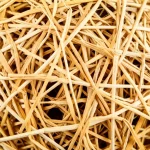 Primo piano dettagliato della texture di un materiale composito rinforzato con fibre naturali derivate da nidi di uccello tessitore, che mostra la struttura intrecciata simile a Voronoi, illuminazione da studio controllata, obiettivo macro 90mm, alta definizione.