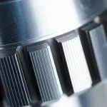 Immagine fotorealistica di un dettaglio del nucleo di un motore LSRM realizzato in Acciaio 1008, con focus sulla texture metallica e sulla precisione della lavorazione dei denti dello statore. Luce laterale controllata per enfatizzare la forma. Obiettivo macro, 100mm, alta definizione, messa a fuoco precisa sulla superficie del materiale.