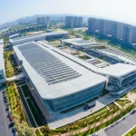 Vista panoramica di un moderno complesso sportivo multifunzionale a Xi'an, integrato nel tessuto urbano con aree verdi circostanti. Fotografia architettonica, obiettivo grandangolare 20mm, luce diurna brillante, messa a fuoco nitida sull'architettura e sul paesaggio.