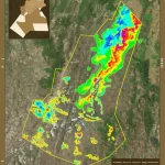 Mappa digitale colorata che mostra le zone di potenziale di ricarica delle acque sotterranee nella regione del Boussellam, sovrapposta a un'immagine satellitare del terreno, stile visualizzazione dati fotorealistica, grandangolo 24mm, con legenda chiara.