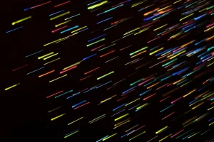 Concetto astratto di ergodicità numerica: una moltitudine di particelle digitali colorate che si muovono casualmente su uno sfondo scuro, inizialmente separate, ma che col tempo si mescolano fino a raggiungere una distribuzione statisticamente uniforme. Stile macrofotografia, obiettivo 100mm, alta definizione dei dettagli, illuminazione drammatica laterale che evidenzia le singole traiettorie prima della convergenza.