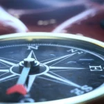 Immagine concettuale di una bussola medica stilizzata puntata verso una rappresentazione astratta di cellule di cancro gastrico, macro lens 80mm, alta definizione, illuminazione controllata e drammatica, sfondo sfocato per enfatizzare la bussola come guida prognostica.