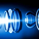 Immagine astratta ad alta tecnologia che mostra un fascio di luce focalizzato che attraversa una serie di lenti ottiche stilizzate, rappresentando il processo di messa a fuoco e deblurring, obiettivo prime 35mm, profondità di campo ridotta, duotone blu e argento.