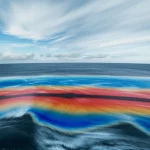 Visualizzazione artistica del fenomeno El Niño nel Pacifico equatoriale, con correnti oceaniche calde (rosse) e fredde (blu) che interagiscono sotto un cielo parzialmente nuvoloso, simulazione generata da un modello di deep learning, wide-angle 10mm, long exposure per nuvole fluide, sharp focus sull'interazione delle correnti.