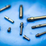 Immagine macro 100mm ad alta definizione di strumenti chirurgici ortopedici, come ancore da sutura e viti cave, disposti su un telo sterile blu, illuminazione chirurgica precisa e focalizzata sugli strumenti, dettaglio elevato.