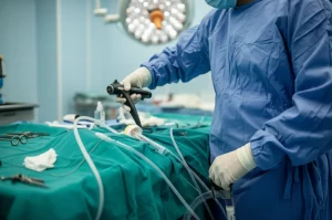 Anestesista esperto che prepara con cura l'attrezzatura per l'intubazione in una sala operatoria moderna e luminosa, con particolare attenzione a un videolaringoscopio e a un tubo endotracheale. Obiettivo prime 35mm, profondità di campo accentuata per isolare l'azione, illuminazione controllata che evidenzia i dettagli, atmosfera professionale e concentrata.