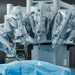 Immagine fotorealistica di una sala operatoria focalizzata sui bracci di un robot chirurgico posizionati con precisione sopra un paziente (fuori fuoco). Illuminazione soffusa e sterile, leggera profondità di campo. Obiettivo prime, 35mm.