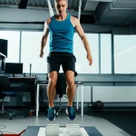 Un runner di endurance maschile, sui 35 anni, che esegue un test del salto verticale continuo su una pedana di misurazione in un laboratorio sportivo. Luce controllata, focus preciso sull'atleta in movimento, stile fotografia sportiva con leggero motion blur per indicare l'azione ripetuta del salto. Teleobiettivo zoom 100mm, fast shutter speed.