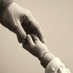 Immagine fotorealistica che mostra una mano adulta che tiene delicatamente una piccola mano di bambino, in bianco e nero con toni seppia, obiettivo 35mm con profondità di campo, simboleggiando la vulnerabilità e la speranza nel trattamento di malattie pediatriche gravi come la SMA.