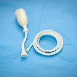 Lente primaria, 35 mm, profondità di campo, immagine fotorealistica di un catetere urinario Foley arrotolato ordinatamente su un drappeggio medico blu sterile, illuminazione clinica morbida, che rappresenta il tema centrale delle infezioni del catetere urinario.