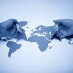 Fotografia concettuale, stile duotone blu e grigio, che mostra due mani diverse che si uniscono per formare un ponte sopra una mappa astratta del mondo, profondità di campo, obiettivo 35mm, simboleggiando l'unione strategica tra multiculturalismo e interculturalismo per la governance della diversità.