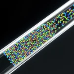 Primo piano fotorealistico di una punta di pipetta trasparente (Lab-in-a-Tip) che rivela al suo interno un array denso e ordinato di microparticelle codificate (GRASPs), illuminate da una luce soffusa che ne esalta la tecnologia avanzata. Lente macro 90mm, alta definizione, illuminazione da studio controllata per dettagli precisi.