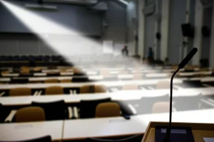 Un podio illuminato da un fascio di luce in una sala conferenze scientifica vuota, simboleggia l'arte della retorica e della persuasione rivolta alla comunità dei ricercatori sull'integrazione delle prospettive di sesso e genere. Fotografia di interni, obiettivo prime 50mm, profondità di campo ridotta, atmosfera evocativa e leggermente drammatica.
