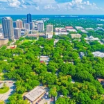 Immagine fotorealistica aerea di Orlando, Florida, con una sovrapposizione digitale che evidenzia la copertura arborea in verde brillante, mostrando dettagli sub-metrici. Lente grandangolare 15mm, focus nitido, luce diurna brillante, che mostra il contrasto tra aree urbane dense e zone verdi.