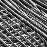 Macro fotografia, 100mm lens, di un tessuto futuristico intrecciato con fibre Ti3C2Tx grigio scuro scintillanti. Linee sottili e luminose percorrono le fibre, suggerendo conducibilità elettrica e termica. Dettagli elevati, illuminazione controllata e drammatica che enfatizza la natura high-tech del materiale.