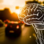 Immagine concettuale di un cervello stilizzato con crepe sottili sovrapposto a una scena di traffico cittadino sfocata al tramonto. Obiettivo 50mm, profondità di campo media, colori caldi contrastanti con la freddezza del concetto di trauma, alta definizione.