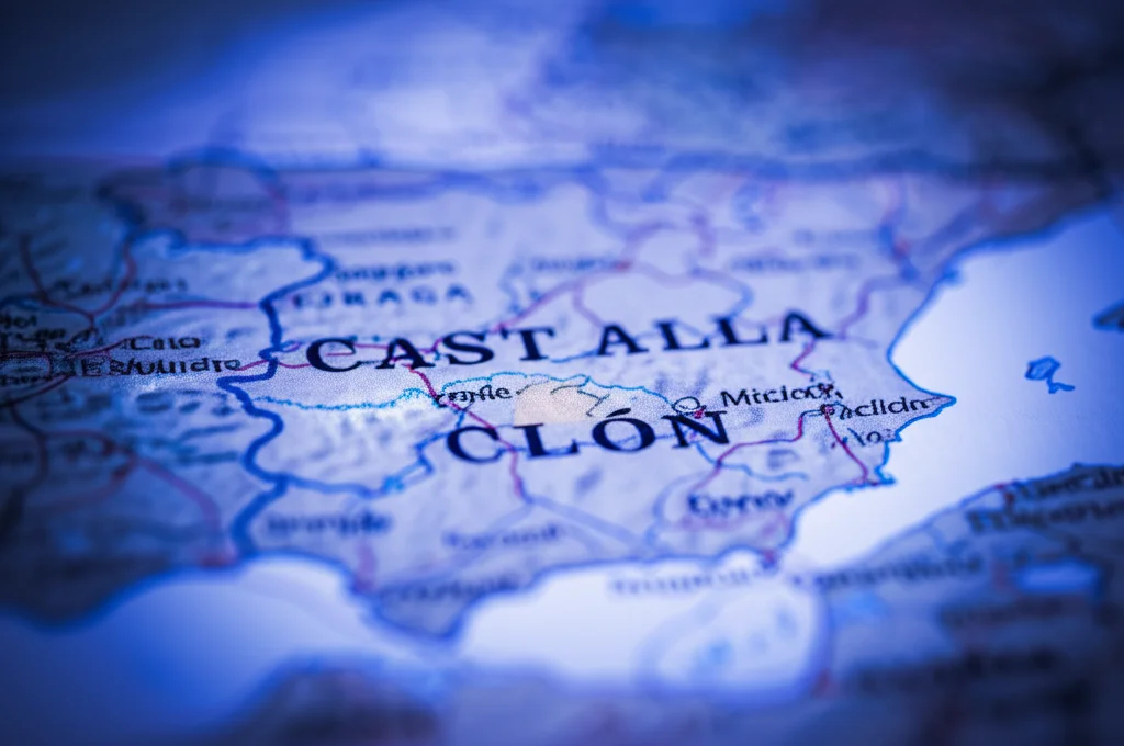 Immagine concettuale che mostra una doppia elica di DNA stilizzata e luminosa sovrapposta a una mappa sfocata della Spagna, con un focus particolare sulla regione di Castilla y León evidenziata. Illuminazione drammatica con toni blu e viola, stile cinematografico, lente 50mm, profondità di campo ridotta per enfatizzare il DNA.