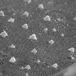 Macro fotografia, 100mm lens, high detail, controlled lighting, che mostra la struttura intricata di un cristallo fotonico rivestito di TiO2, parzialmente coperto da un idrogel trasparente contenente enzimi. La luce si riflette in modo selettivo dalla superficie nanostrutturata, evidenziando il concetto di biosensore ottico ibrido.