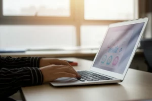 Fotografia di un'aula universitaria moderna e luminosa, focalizzata su un laptop aperto su una piattaforma di apprendimento musicale online. Sullo schermo, si intravede un'interfaccia utente con grafici di valutazione stilizzati e icone musicali. In primo piano, sfocata, una mano che interagisce delicatamente con il touchpad. Obiettivo prime 35mm, profondità di campo ridotta per mettere a fuoco il laptop, illuminazione controllata che mescola luce naturale dalla finestra e luce artificiale calda, creando un ambiente accogliente e tecnologico.