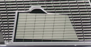 Immagine fotorealistica, lente macro 100mm, che mostra un dettaglio ravvicinato di un fotorilevatore ibrido grafene-punti quantici PbS su un wafer di silicio, evidenziando la struttura nanometrica e l'interfaccia tra i materiali, illuminazione high-tech controllata.