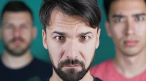 Diverse persone, rappresentative della popolazione italiana, esprimono emozioni contrastanti riguardo ai vaccini, simboleggiando i diversi profili psicologici. Fotografia ritratto, obiettivo 35mm, profondità di campo per mettere a fuoco le espressioni individuali ma mantenere un senso di collettività.