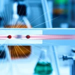 Primo piano fotorealistico di un sensore a doppio nanoporo in plastica su un banco di laboratorio, con fasci di luce stilizzati che simulano il passaggio di singole molecole proteiche attraverso i due pori e il canale di volo intermedio. Obiettivo macro 60mm, alta definizione, illuminazione controllata da laboratorio, focus selettivo sui nanopori, sfondo leggermente sfocato con strumentazione scientifica.