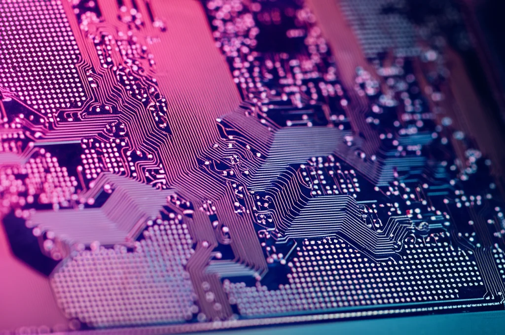 Macro fotografia, 85mm macro lens, di una superficie di un microchip in silicio che mostra intricati percorsi circuitali, high detail, precise focusing, controlled studio lighting che evidenzia la complessità dei circuiti integrati e le connessioni logiche.