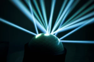 Immagine concettuale della radioterapia stereotassica (SRT) che colpisce con precisione millimetrica una cavità chirurgica nel cervello dopo la rimozione di una metastasi. Si vedono fasci di luce convergenti sul target. Obiettivo prime 35mm, profondità di campo che isola l'area trattata, luce focalizzata e high tech.