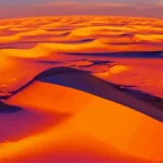 Immagine fotorealistica del deserto egiziano al tramonto, con sovrapposta una mappa termica traslucida che mostra le zone di alto flusso di calore in rosso/arancione e quelle fredde in blu. Stile landscape wide-angle 20mm, long exposure per nuvole soffuse, focus nitido sulla mappa termica e sulle texture del deserto.