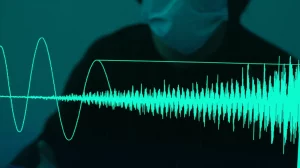 Immagine fotorealistica di un'onda sonora complessa visualizzata su uno schermo digitale, con sovrapposta la forma d'onda stilizzata della wavelet madre Db16 che si adatta perfettamente a una sezione del segnale. Sullo sfondo, una persona indistinta indossa una mascherina chirurgica. Obiettivo prime 50mm, profondità di campo ridotta, illuminazione d'atmosfera high-tech, duotone blu e verde.