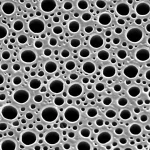 Immagine fotorealistica, obiettivo macro 100mm, di un campione di ossido di alluminio anodico (AAO) trattato in superficie, illuminazione controllata per evidenziare la nanostruttura porosa regolare e l'effetto del trattamento, alta definizione.