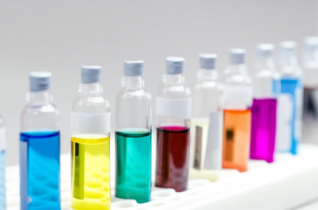Fotografia di laboratorio che mostra una fila di fiale per campioni GC-MS contenenti estratti liquidi colorati derivati dal Daqu, pronte per l'analisi. Illuminazione da laboratorio brillante, messa a fuoco precisa sulle etichette delle fiale, obiettivo macro 60mm.