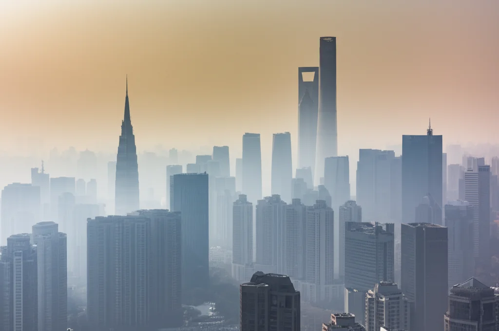 Fotografia di paesaggio urbano di Shenzhen in una giornata invernale nebbiosa, teleobiettivo 200mm, che mostra l'accumulo di foschia (smog/PM2.5) tra i grattacieli, con una luce solare diffusa che fatica a penetrare, simboleggiando l'intrappolamento degli inquinanti e il loro contributo all'isola di calore invernale.