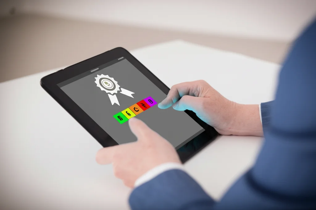 Primo piano sulle mani di una persona seduta a una scrivania, impegnata in un test cognitivo su un tablet che mostra parole colorate (Emotional Stroop Task). Sullo schermo è visibile anche un'icona che simboleggia una ricompensa (es. una moneta). L'illuminazione è controllata e focalizzata sulle mani e sul tablet, lo sfondo è sfocato. Fotografia macro, obiettivo 60mm, alto dettaglio.