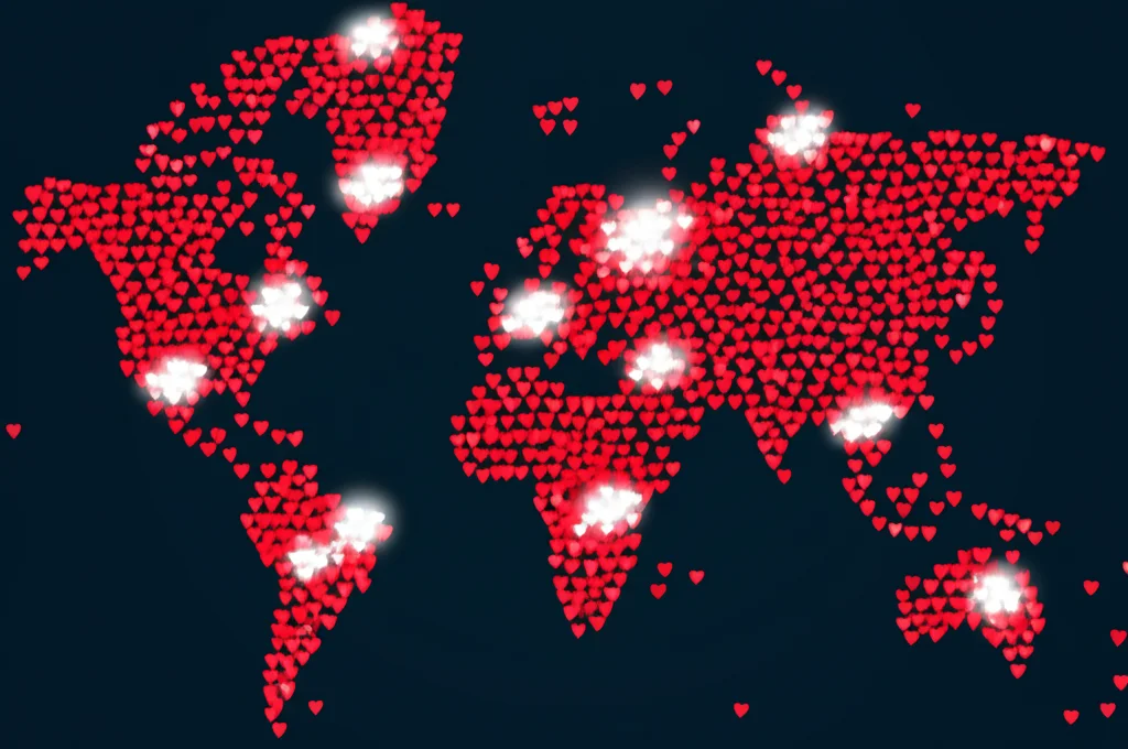 Lenti macro, 85 mm, alto dettaglio di una mappa del mondo stilizzata realizzata con forme di cuore rosso interconnesse, alcuni luminosi più luminosi (che rappresentano un alto carico HHD) e alcuni dimmer (bassa carico), controllata l'illuminazione che enfatizza la rete globale e i punti dati dal 1990 al 2021.