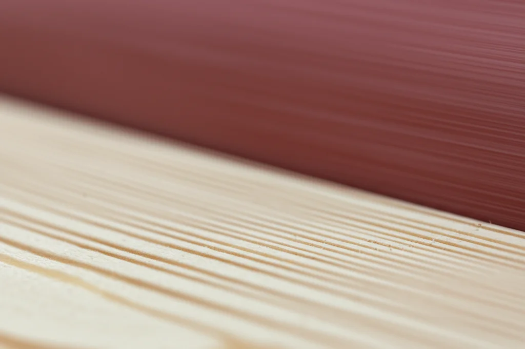 Macro photography, 90mm lens, close-up di una levigatrice a tamburo con carta P100 che lavora su una tavola di pino, mostrando la polvere di legno fine e le scanalature parallele create sulla superficie, high detail, controlled lighting.