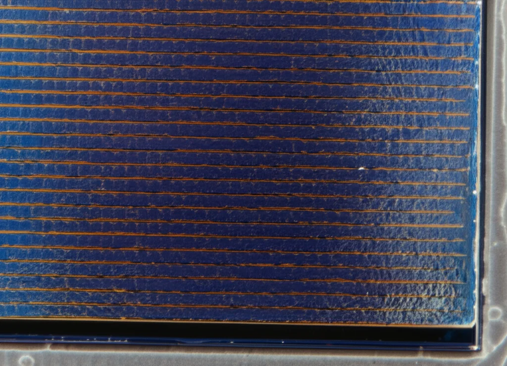 Lenti macro, 90 mm, alti dettagli di motivi intricati su una superficie di cella solare perovskite, illuminazione controllata che evidenzia la consistenza e l'efficienza, che rappresentano l'innovazione tecnologica nell'energia solare.