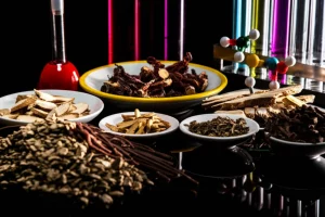 Fotografia still life con lente macro 90mm di una composizione artistica che unisce elementi della medicina tradizionale cinese (erbe essiccate della ricetta Chaige Kangyi, piccole ciotole in ceramica) ed elementi scientifici moderni (pipette, provette con liquidi colorati, una rappresentazione stilizzata di molecole come IL-6). Illuminazione drammatica e controllata, alta definizione, sfondo scuro per simboleggiare l'esplorazione dei meccanismi d'azione.