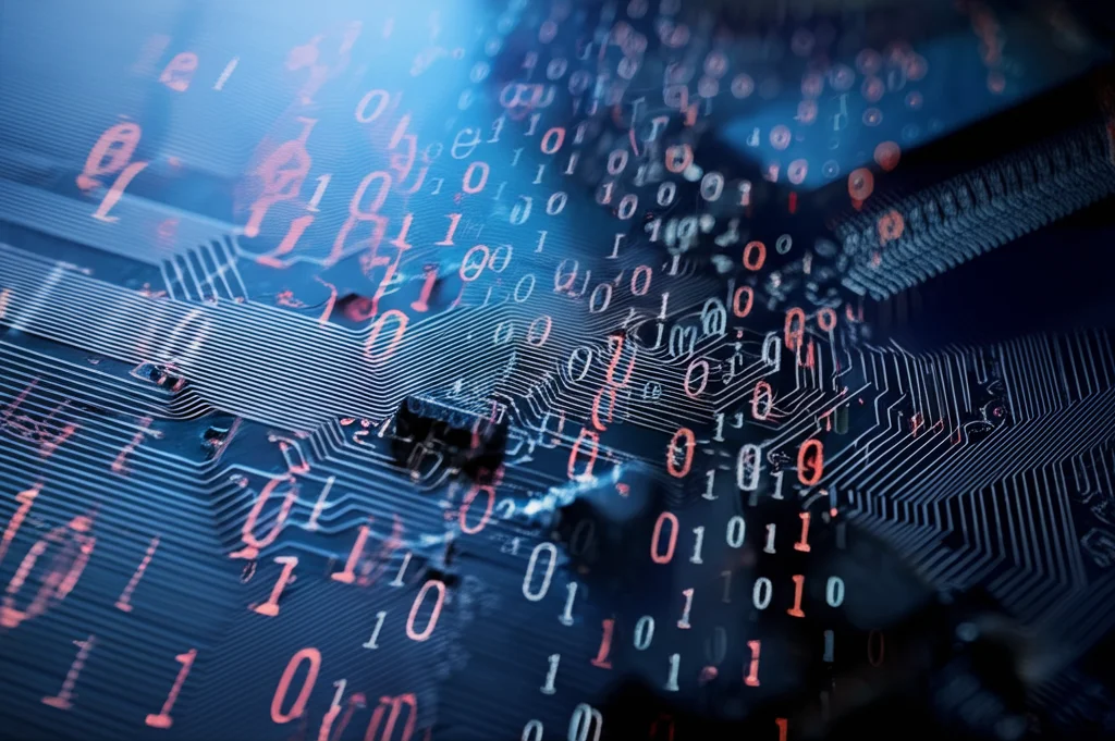Fotografia macro ad alto dettaglio di un chip di computer con linee di codice binarie (0 e 1) sovrapposte, alcune linee sono sfocate e distorte per rappresentare l'offuscamento del malware. Illuminazione controllata e drammatica, obiettivo macro 100mm, messa a fuoco precisa.