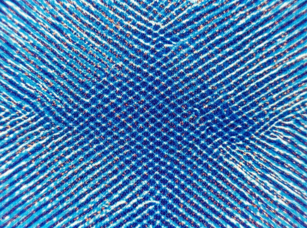 Simulazione scientifica che mostra la rottura di bande ordinate di particelle (rosse e blu) a causa della nucleazione spontanea di 'goccioline' di fase opposta. Obiettivo grandangolare 24mm, messa a fuoco nitida per mostrare sia l'ordine residuo che il disordine emergente, profondità di campo.