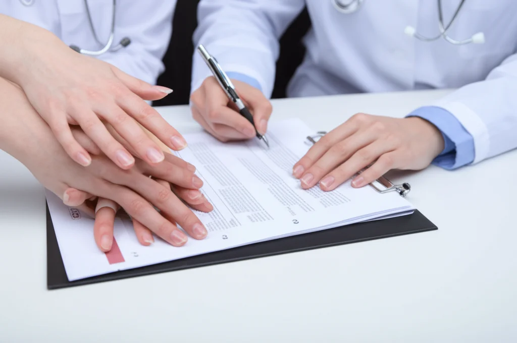 Macro fotografia, 100mm macro lens, di mani diverse (medico, infermiere, tecnico di laboratorio riconoscibili dalle divise o strumenti) che si incontrano delicatamente sopra una cartella clinica aperta, high detail, precise focusing, controlled lighting, simboleggia la collaborazione interdisciplinare necessaria.