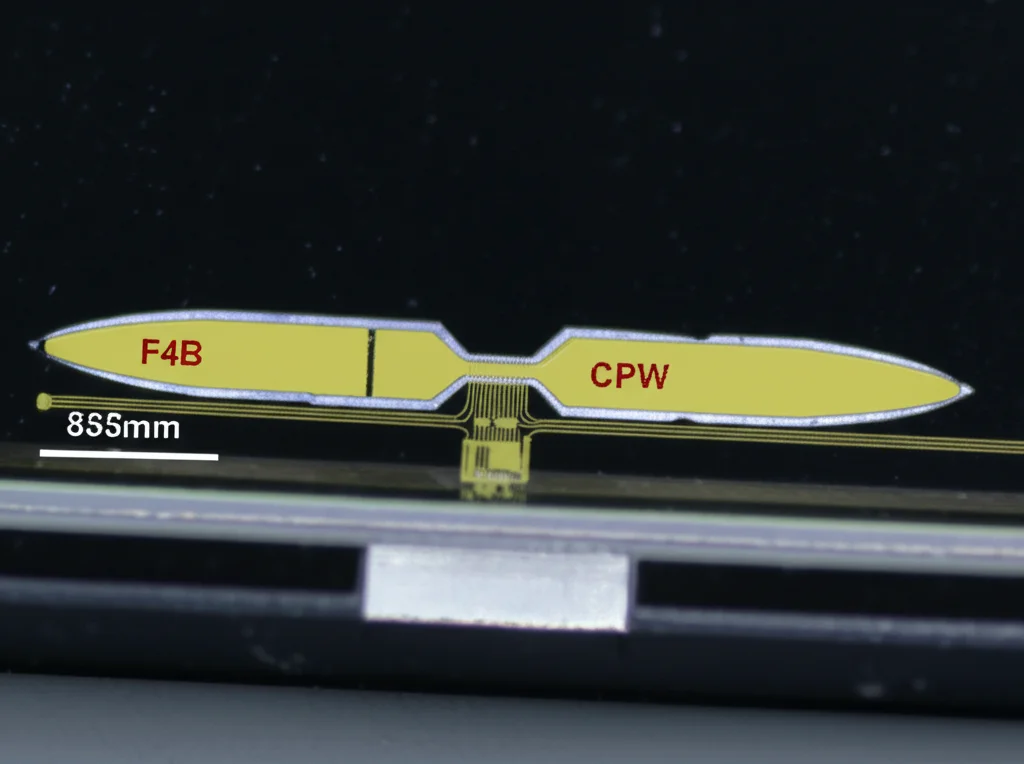 Fotografia macro, obiettivo 85mm, di un prototipo compatto di antenna SWB su substrato F4B, che mostra l'alimentazione CPW e il radiatore semi-ellittico. Alto dettaglio, messa a fuoco precisa, illuminazione controllata da laboratorio.