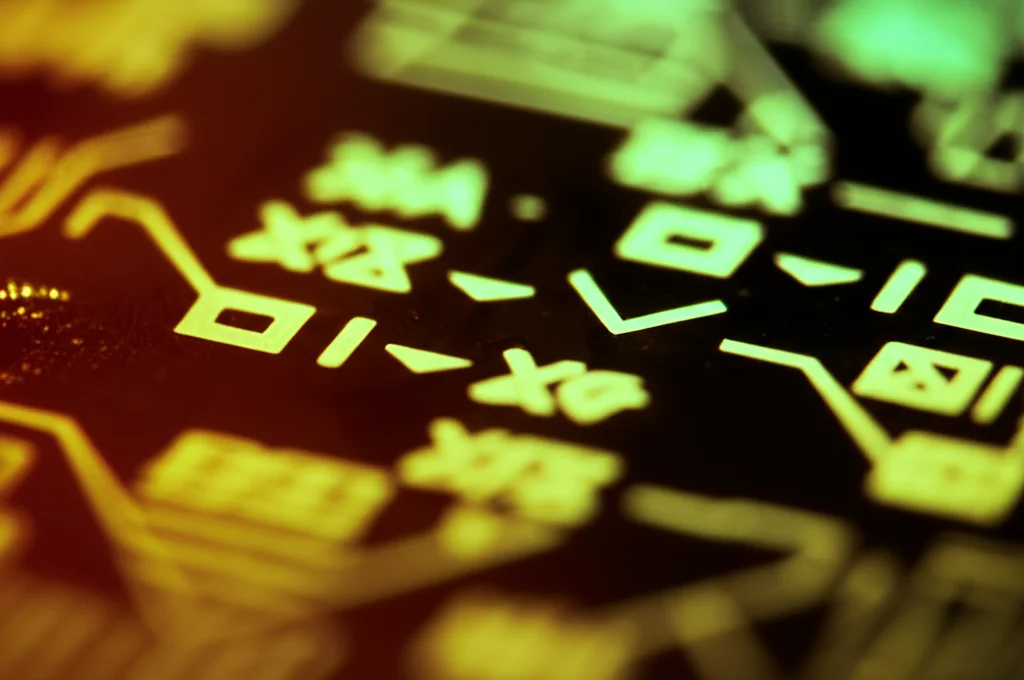 Fotografia macro di un chip di silicio illuminato da luce controllata e precisa, con simboli logici come e#x25A1; e e#x25C7; incisi o proiettati sulla superficie, obiettivo macro 90mm, alta definizione, messa a fuoco selettiva.