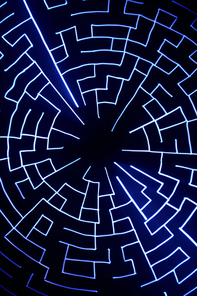Immagine astratta grandangolare di un labirinto logico complesso, visualizzato come percorsi luminosi in uno spazio scuro, alcuni che convergono verso una luce centrale (conclusione), altri che terminano in vicoli ciechi (inconsistenze), obiettivo 15mm, lunga esposizione per scie luminose fluide.