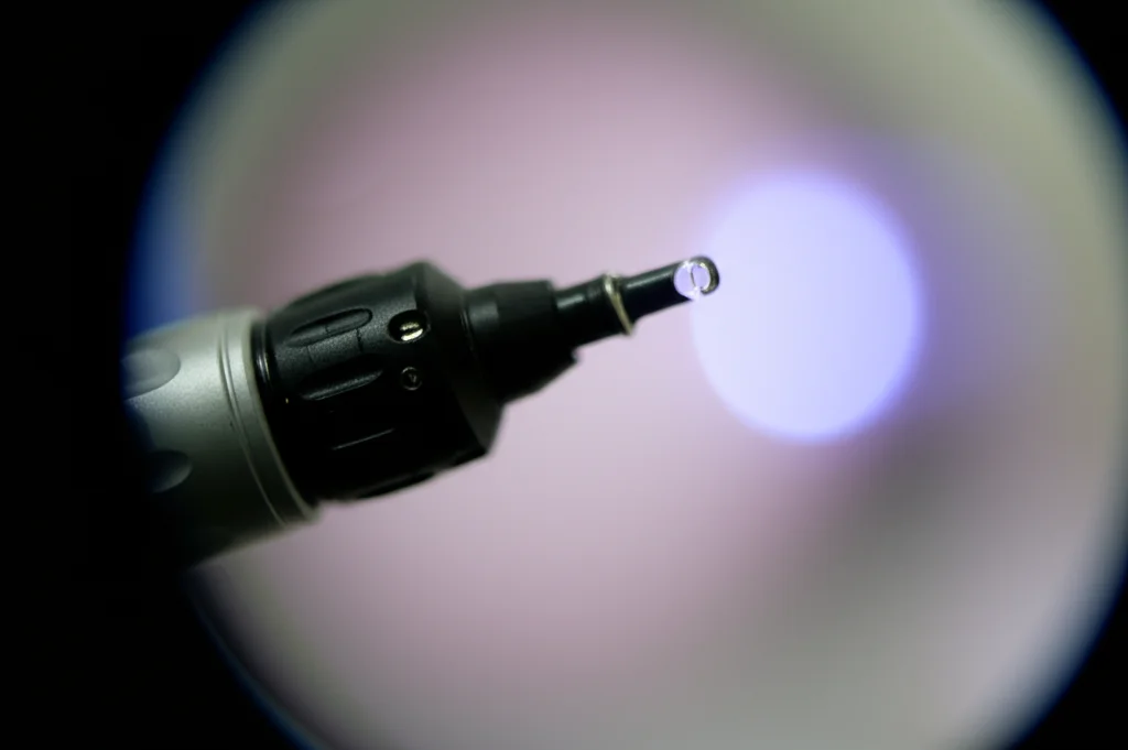 Immagine macro di un broncoscopio flessibile pediatrico illuminato, pronto per l'esame, messa a fuoco precisa sui dettagli della punta, illuminazione controllata, obiettivo macro 80mm.