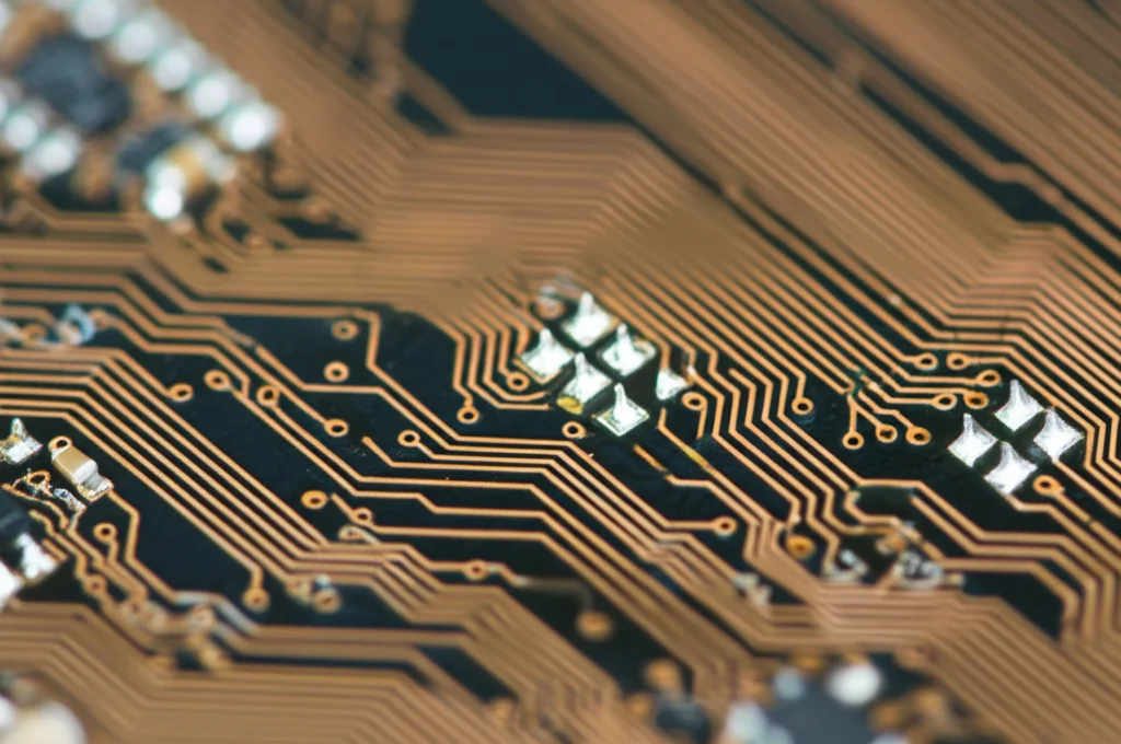 Fotografia macro di circuiti elettronici complessi su una scheda madre, con alcune piste interrotte o deviate in modo evidente, obiettivo macro 100mm, messa a fuoco precisa sui dettagli delle anomalie simulate, illuminazione da studio.