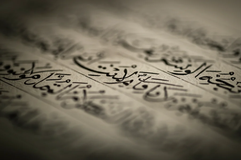 Primo piano macro di un antico manoscritto arabo con versi poetici, illuminazione controllata e drammatica stile film noir, messa a fuoco precisa sui caratteri, obiettivo macro 90mm, alta definizione.