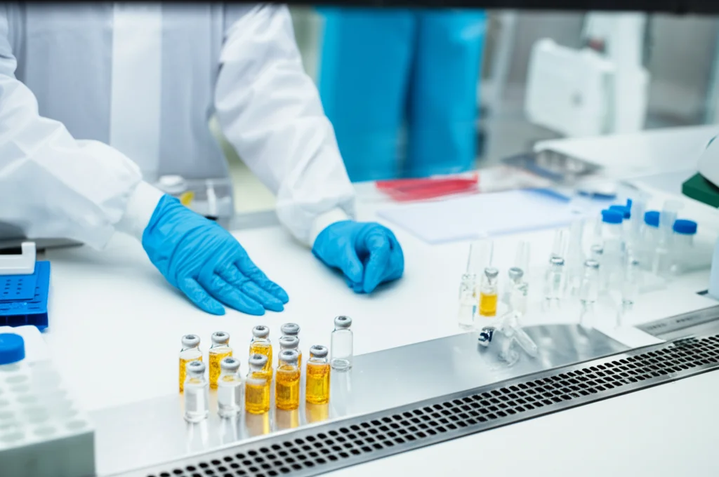 Natura morta, obiettivo macro 100mm, che mostra mani attente in guanti che organizzano con precisione diverse fiale di antibiotici su un banco da laboratorio sterile, alto dettaglio, illuminazione controllata, simboleggiando la gestione antimicrobica e l'uso razionale.