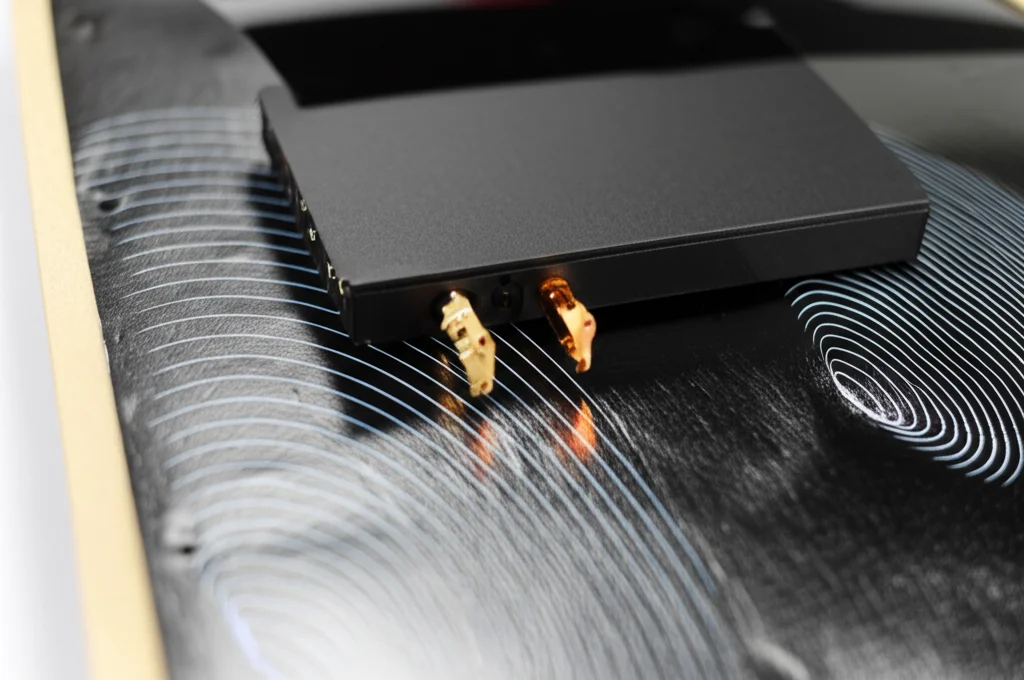 Concetto fotorealistico di onde Elettromagnetiche Bloccato da un foglio di Airgel composito nero, visto con obiettivo grandangolare da 24mm, proteggendo un dispositivo di elettronico. Immagine di concetto fotorealistica, lente da 24 mm ad angolo largo, raffigurante onde elettromagnetiche (rappresentate come linee/griglie luminose astratte) che vengono riflesse e assorbite da un foglio del materiale composito di Airgel nero, proteggendo un dispositivo elettronico generico dietro di esso, focus acuto sulla zona di interazione.