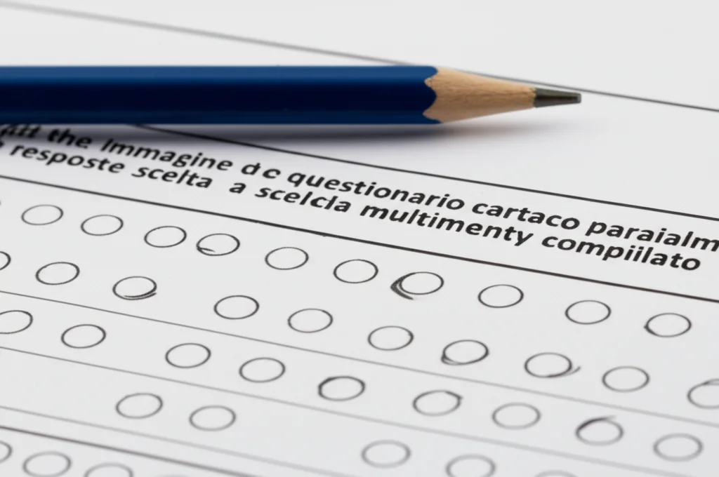 Immagine macro di un questionario cartaceo con risposte a scelta multipla parzialmente compilato, una matita appoggiata sopra. Luce da studio controllata, messa a fuoco precisa sui dettagli del foglio e della grafite. Obiettivo macro 100mm, alta definizione.